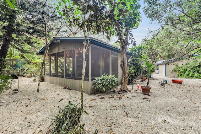 view of property exterior with a sunroom