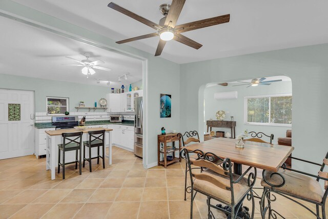 dining area with light tile patterned flooring and a wall unit AC