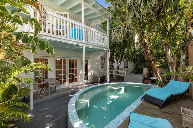 view of swimming pool featuring a deck and french doors