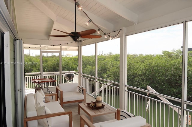 sunroom / solarium featuring vaulted ceiling with beams, wood ceiling, a healthy amount of sunlight, and ceiling fan