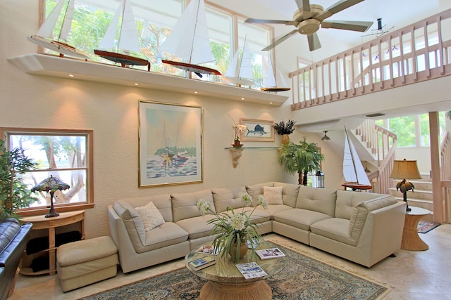 living room with a high ceiling and ceiling fan