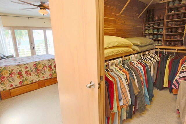 spacious closet featuring french doors, ceiling fan, and carpet