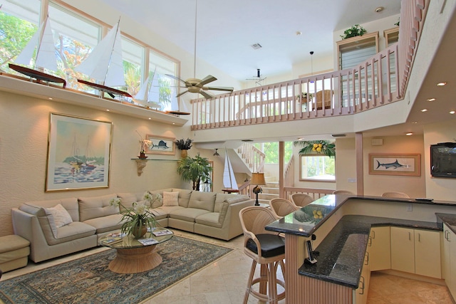 living room with a towering ceiling and ceiling fan