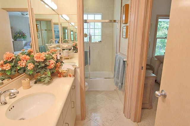 full bathroom featuring enclosed tub / shower combo, vanity, and toilet