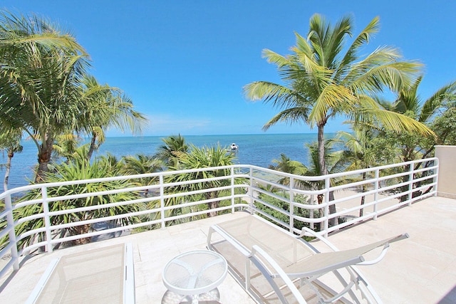 view of patio / terrace featuring a water view and a balcony