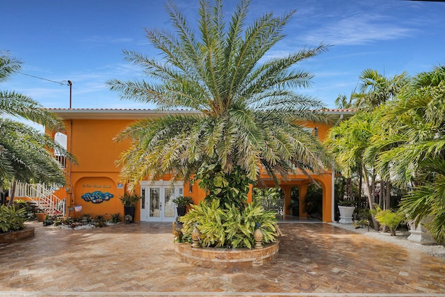 view of front facade featuring stucco siding and french doors