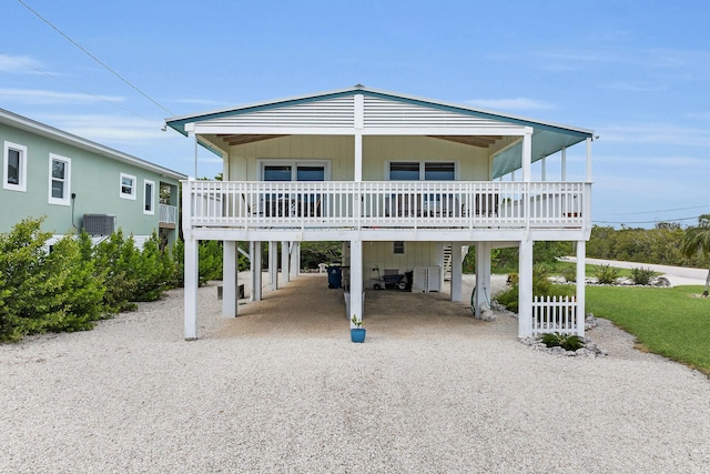 view of front of home featuring a carport, central AC unit, and driveway