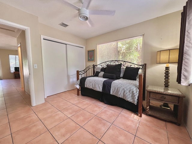 tiled bedroom featuring multiple windows, a closet, and ceiling fan