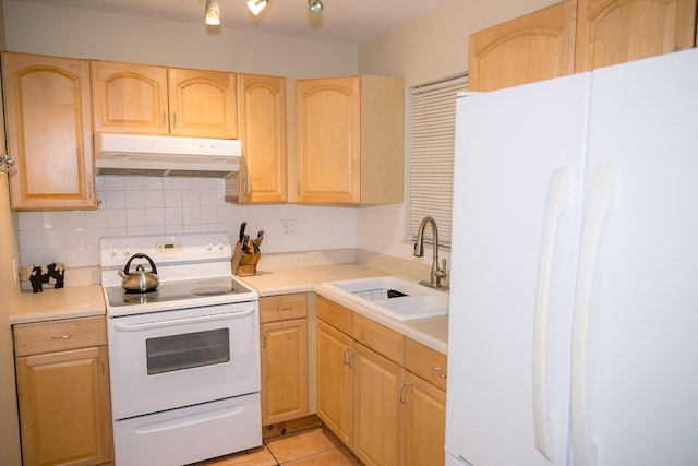 kitchen featuring light brown cabinetry, sink, white appliances, and tasteful backsplash