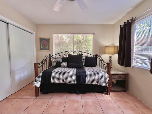 bedroom featuring multiple windows, a closet, and light tile patterned flooring