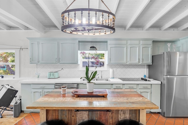 kitchen with backsplash, beam ceiling, stainless steel appliances, and light tile patterned flooring