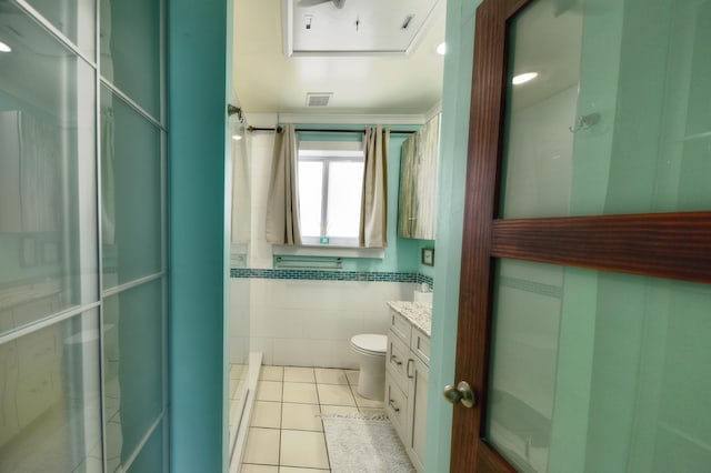 full bathroom featuring tile walls, toilet, a stall shower, vanity, and tile patterned flooring