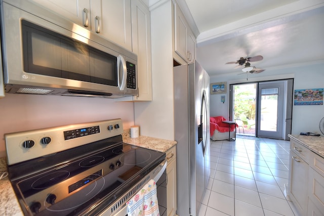 kitchen featuring light tile patterned floors, stainless steel appliances, white cabinets, ceiling fan, and light stone countertops