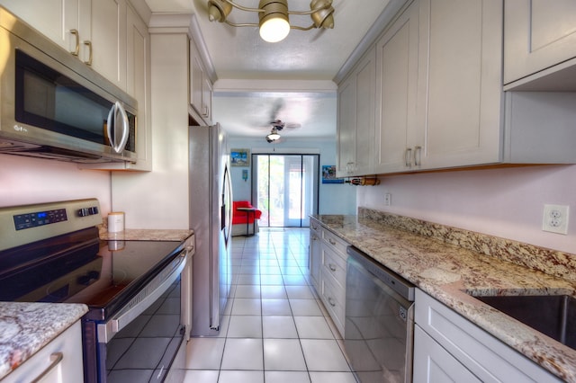 kitchen with light stone countertops, appliances with stainless steel finishes, and light tile patterned flooring