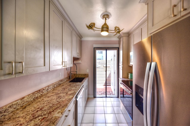 kitchen with light stone counters, stainless steel appliances, a sink, and light tile patterned flooring