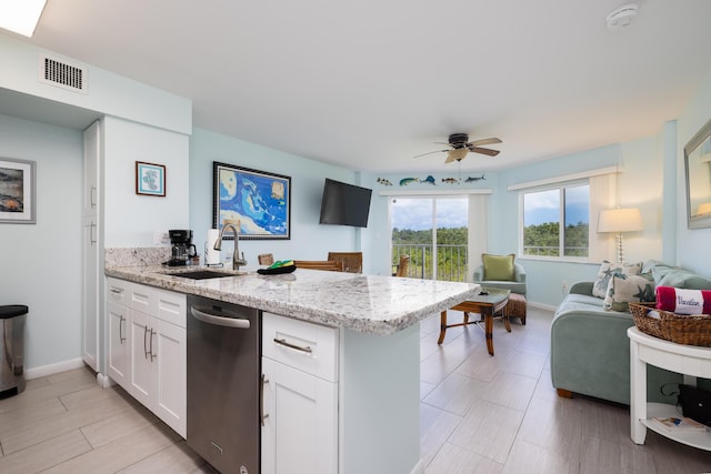 kitchen featuring a peninsula, a sink, visible vents, white cabinetry, and open floor plan