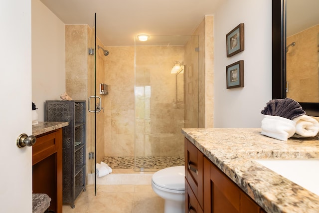 bathroom featuring toilet, a stall shower, tile patterned floors, and vanity