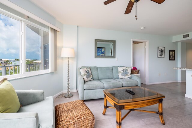 living area with visible vents, ceiling fan, baseboards, and wood finished floors