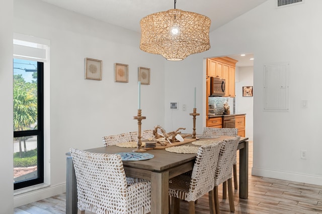 9812 Windward Ave, Key Largo, FL 33037 - dining space featuring electric panel, light wood-style flooring, and a chandelier