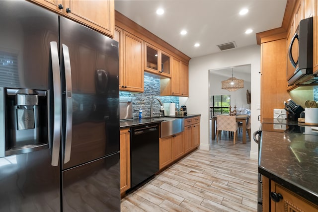 9812 Windward Ave, Key Largo, FL 33037 - kitchen featuring black appliances, decorative backsplash, recessed lighting, light wood-type flooring, and brown cabinetry