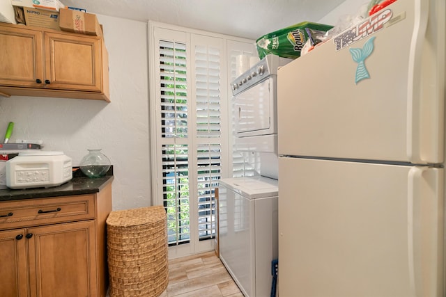 9812 Windward Ave, Key Largo, FL 33037 - laundry room with stacked washer and clothes dryer, cabinet space, and light wood-style floors