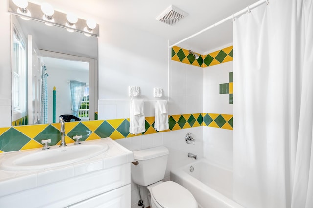 full bathroom with vanity, tile walls, shower / tub combo, and toilet