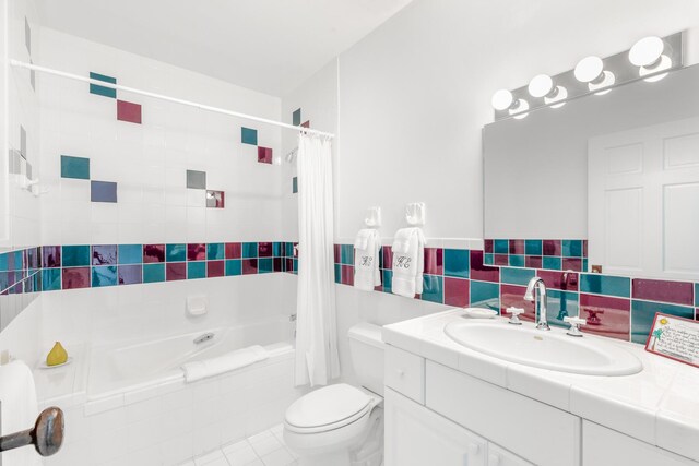 full bathroom featuring tile walls, vanity, toilet, shower / bath combo, and tile patterned floors