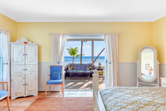 bedroom featuring a water view, ornamental molding, access to exterior, and light tile patterned floors