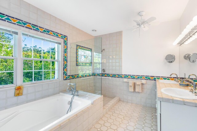 bathroom featuring plus walk in shower, tile walls, and vanity