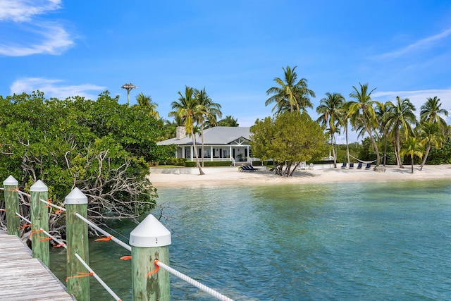 dock area with a water view and a beach view