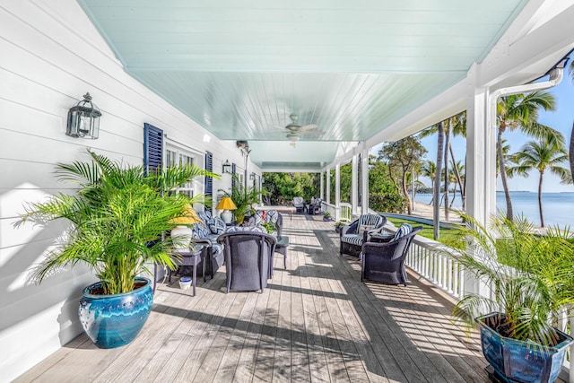 wooden terrace featuring a water view and ceiling fan