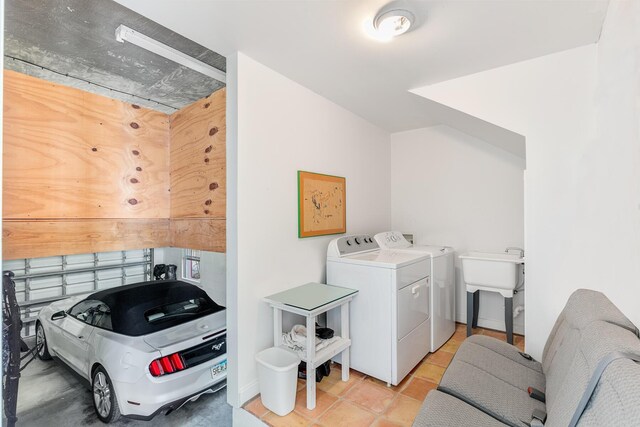 clothes washing area featuring separate washer and dryer, sink, and light tile patterned floors