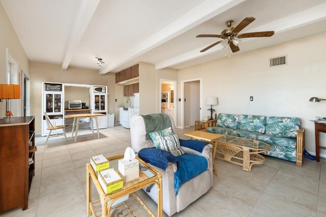 living room with beamed ceiling, ceiling fan, and light tile patterned floors