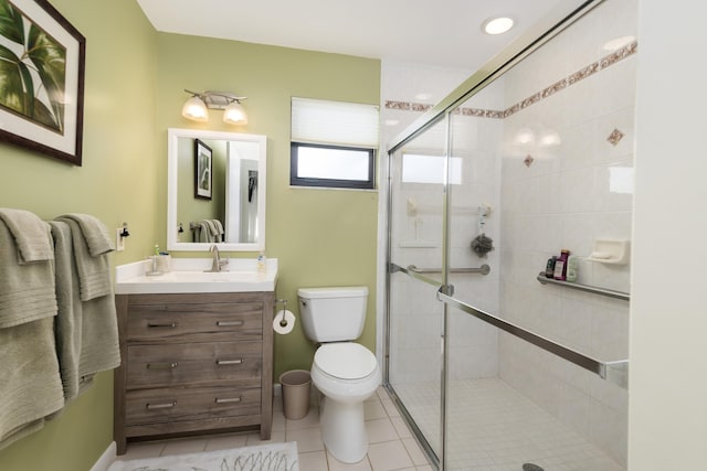 bathroom with tile patterned flooring, vanity, toilet, and walk in shower