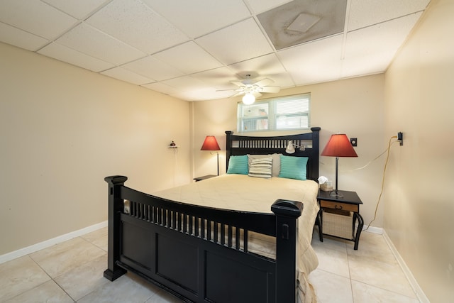 tiled bedroom featuring ceiling fan and a drop ceiling