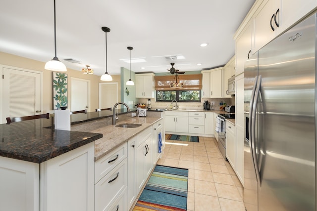 kitchen featuring stainless steel appliances, a center island, sink, and hanging light fixtures