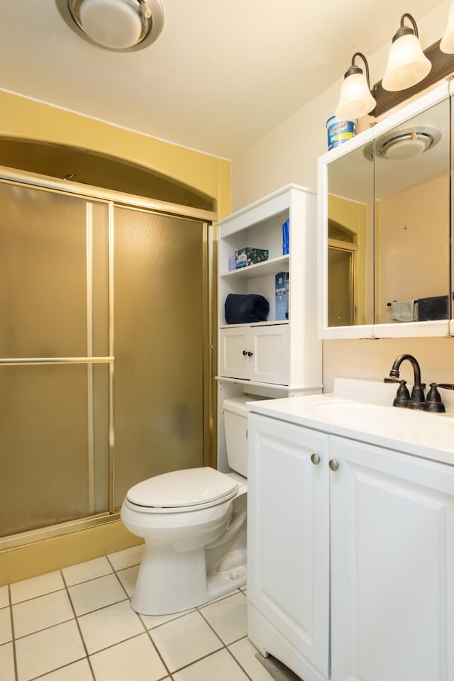 bathroom featuring tile patterned floors, vanity, toilet, and an enclosed shower