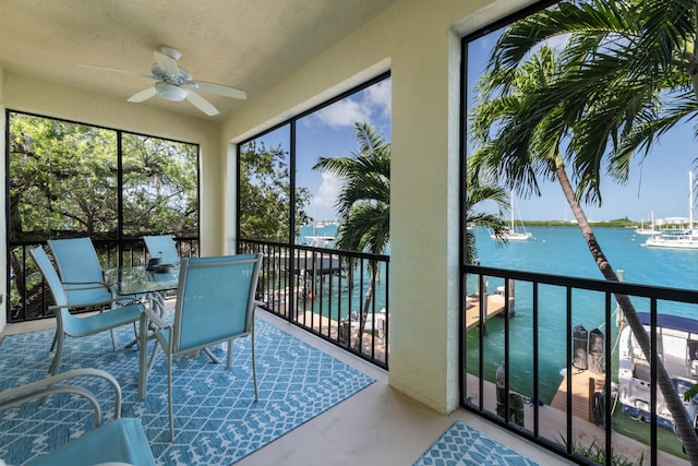 sunroom featuring a water view and ceiling fan