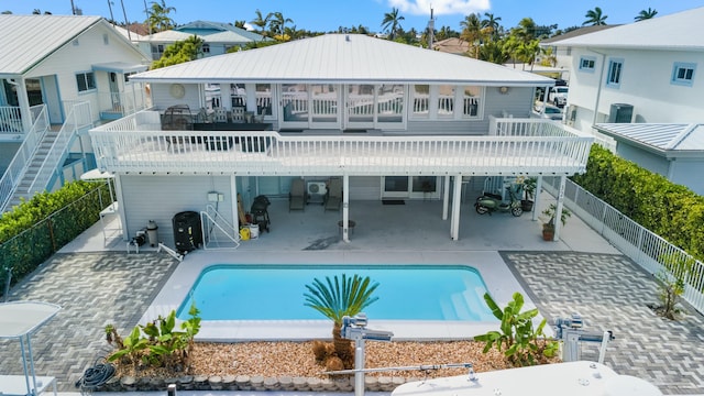 back of house with metal roof, a patio, a fenced backyard, and a fenced in pool