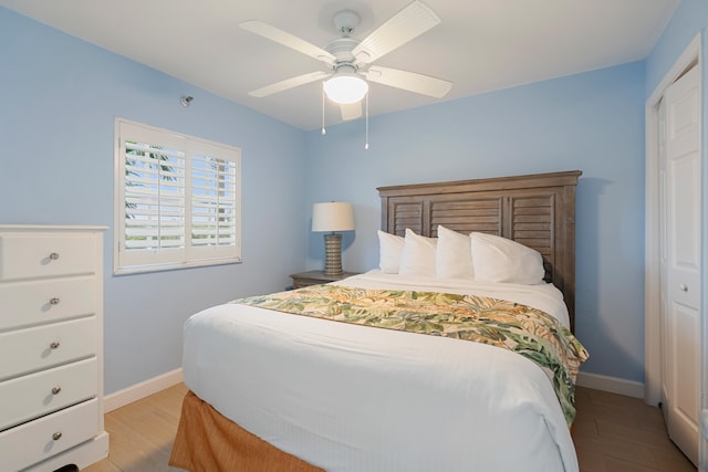 bedroom with light hardwood / wood-style floors, a closet, and ceiling fan