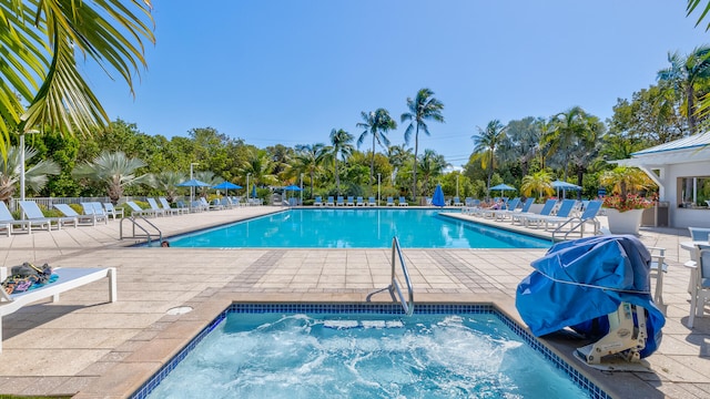 view of pool featuring a community hot tub and a patio area