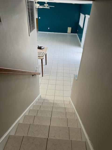 stairs featuring tile patterned flooring and ceiling fan