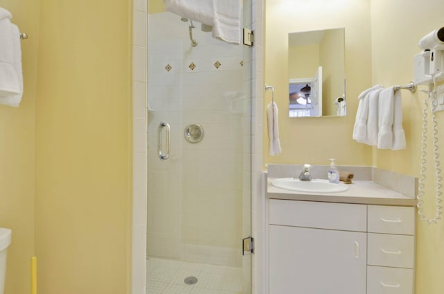 bathroom featuring a shower with door and vanity