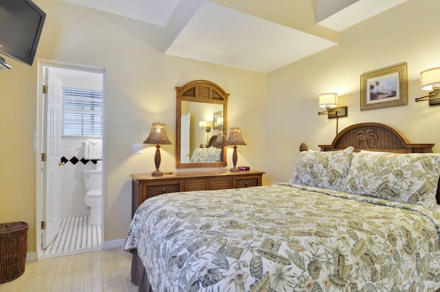 bedroom featuring ensuite bath and light wood-type flooring