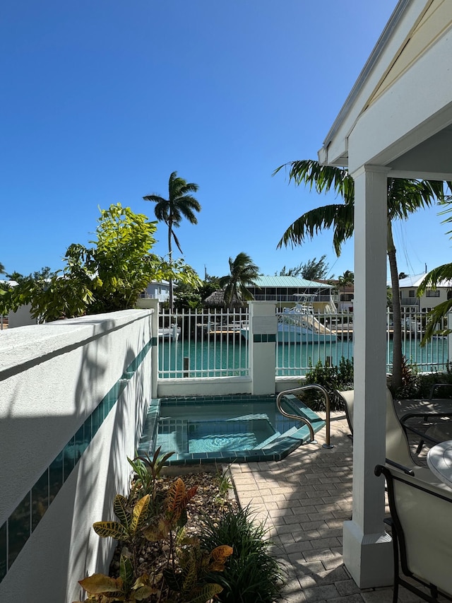 view of pool featuring a patio area and a water view