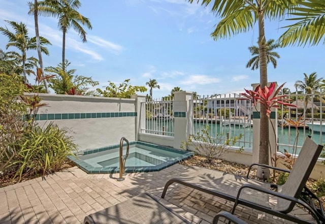 view of pool featuring a water view and an in ground hot tub