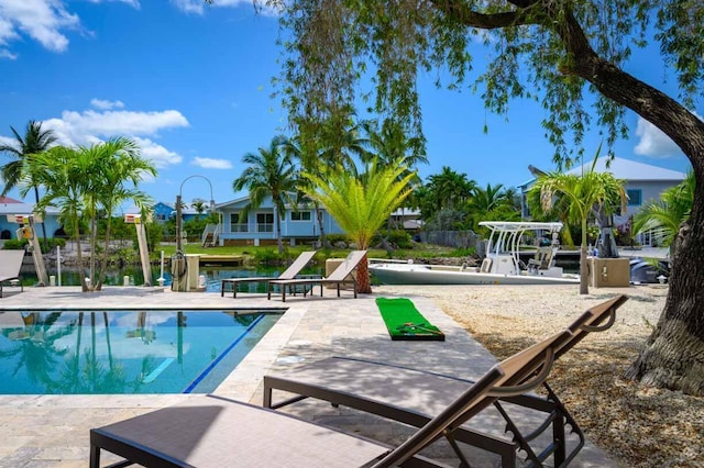 view of swimming pool featuring a water view and a patio area