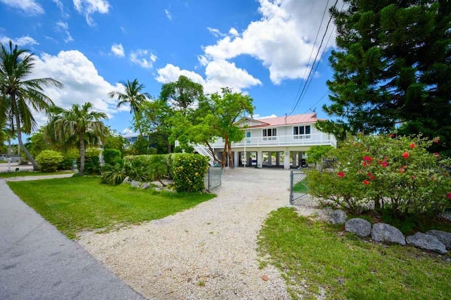 beach home featuring a carport and a front yard