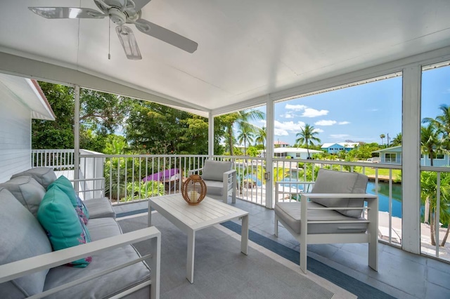 sunroom / solarium featuring a water view, ceiling fan, and plenty of natural light