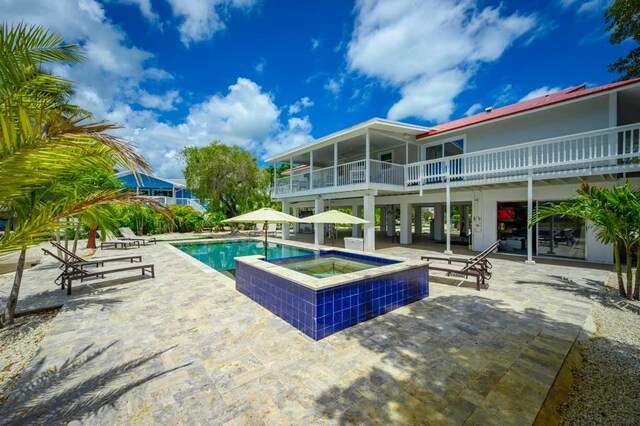 view of swimming pool featuring an in ground hot tub and a patio